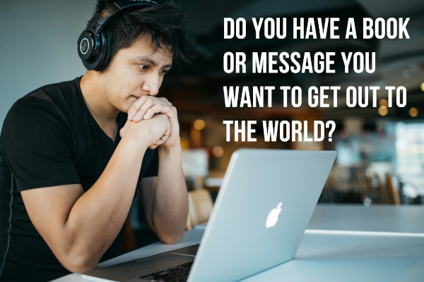 Middle eastern guy with headphones starting at his computer in maybe a web cafe with the words "Do you have a book or message you want to get out to the world?"